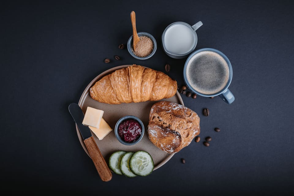 Frühstücksteller mit Gipfeli, Brot, Butter, Konfitüre und Kaffee