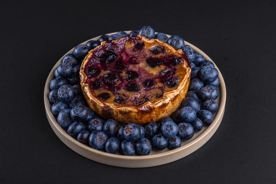 Heidelbeerkuchen, umgeben von frischen Heidelbeeren