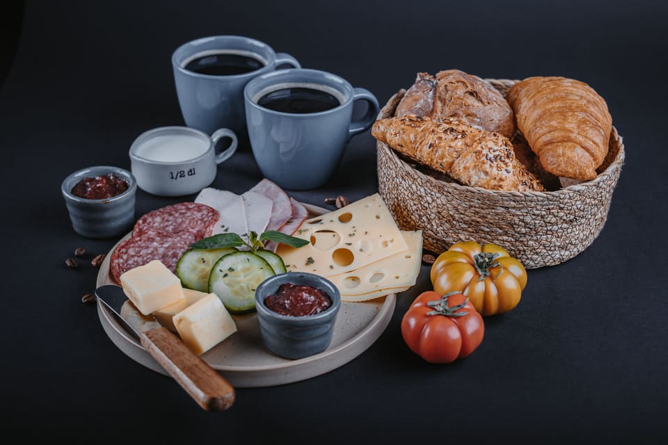 Frühstück für zwei mit Brotkorb, Aufschnitt, Käse, Konfitüre und Kaffee