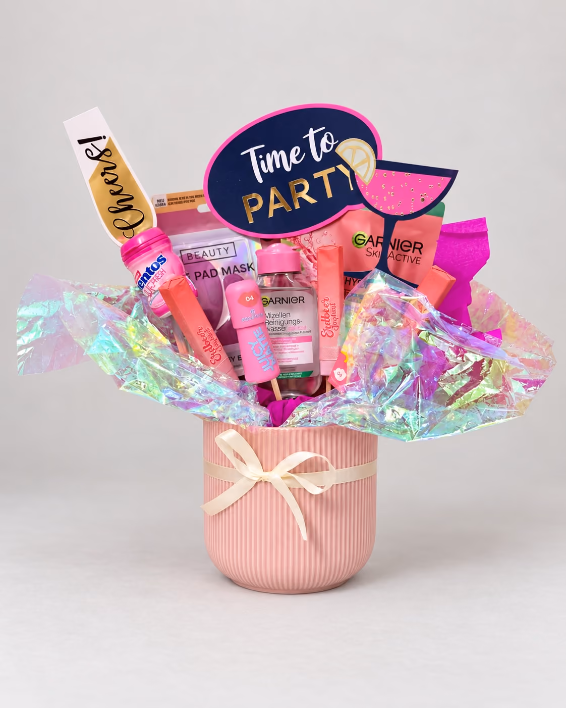 Rosa Topf mit Kosmetik, Kaugummi, Partysteckern und Schillerfolie
